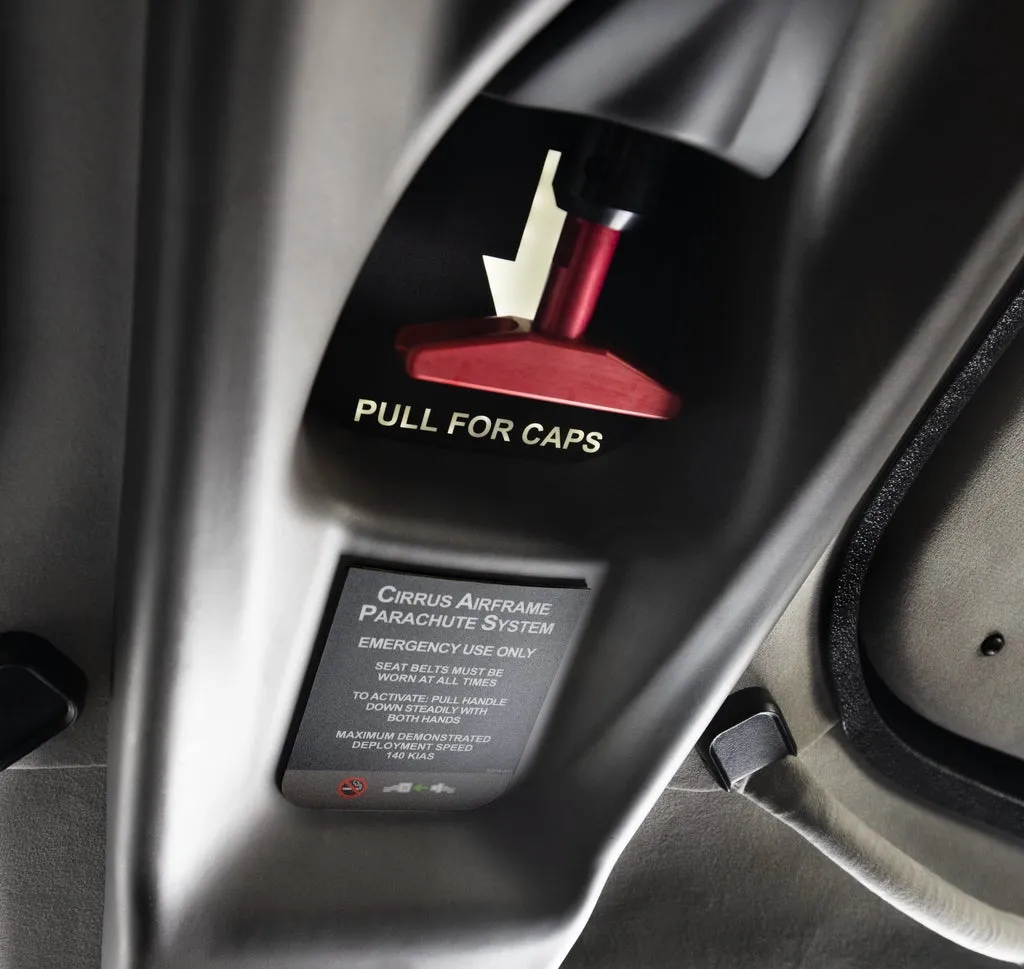 Passenger pressing the Safe Return button inside Cirrus cockpit